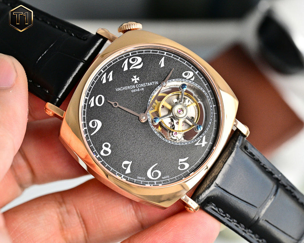 Mechanical wristwatch front view with black dial, rose-gold case, black leather strap