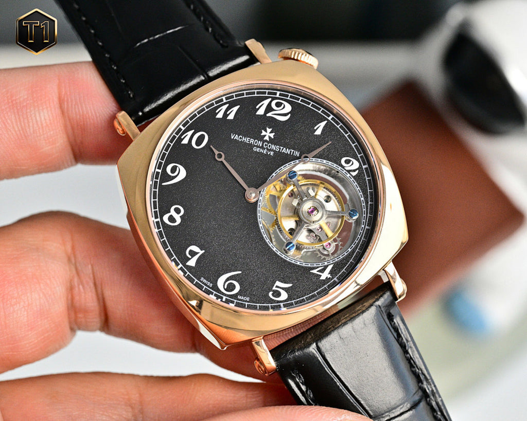 Mechanical wristwatch front view with black dial and visible gold-toned movement