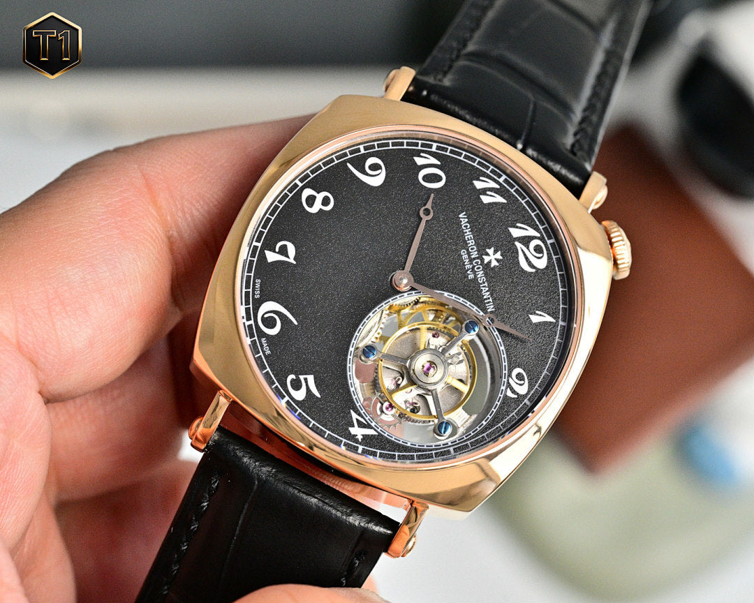 Mechanical wristwatch with black dial, rose-gold case, visible movement, leather strap