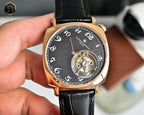 Mechanical wristwatch front view with black dial, rose-gold bezel, leather strap