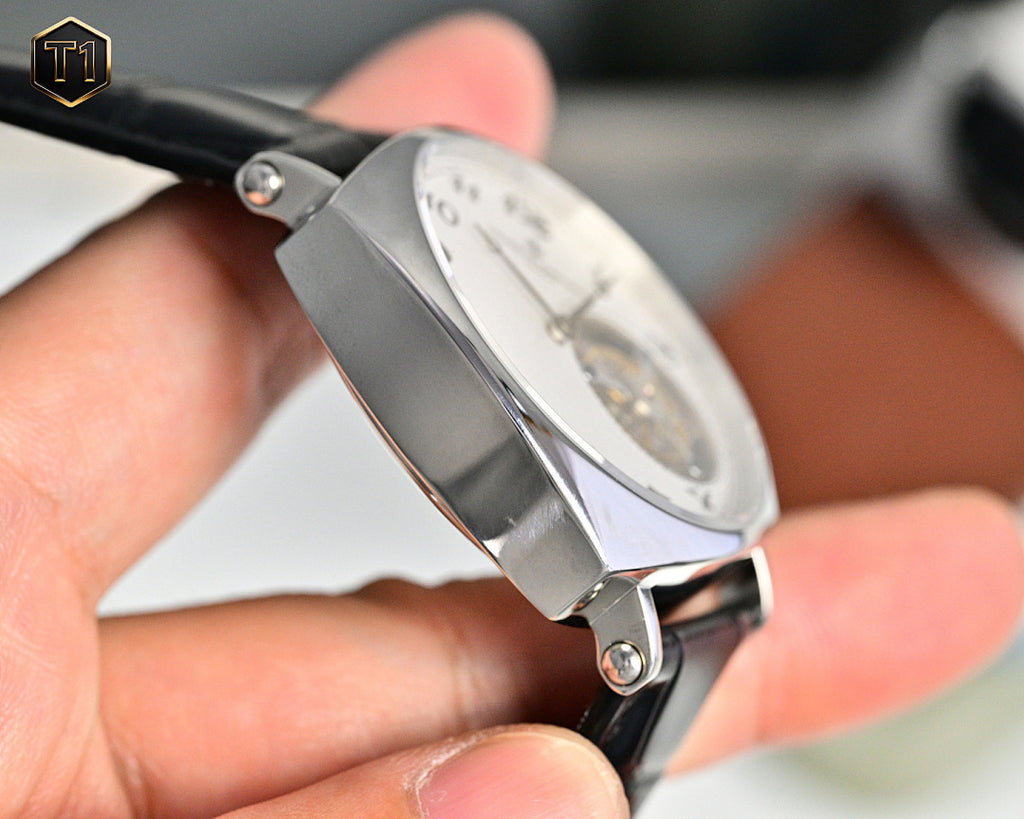 Stainless steel watch with black leather strap, angled side view of case and crystal.