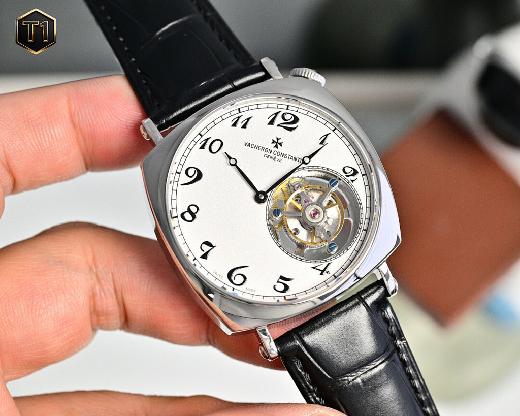 Stainless steel skeleton watch with black leather strap, white dial and exposed movement.