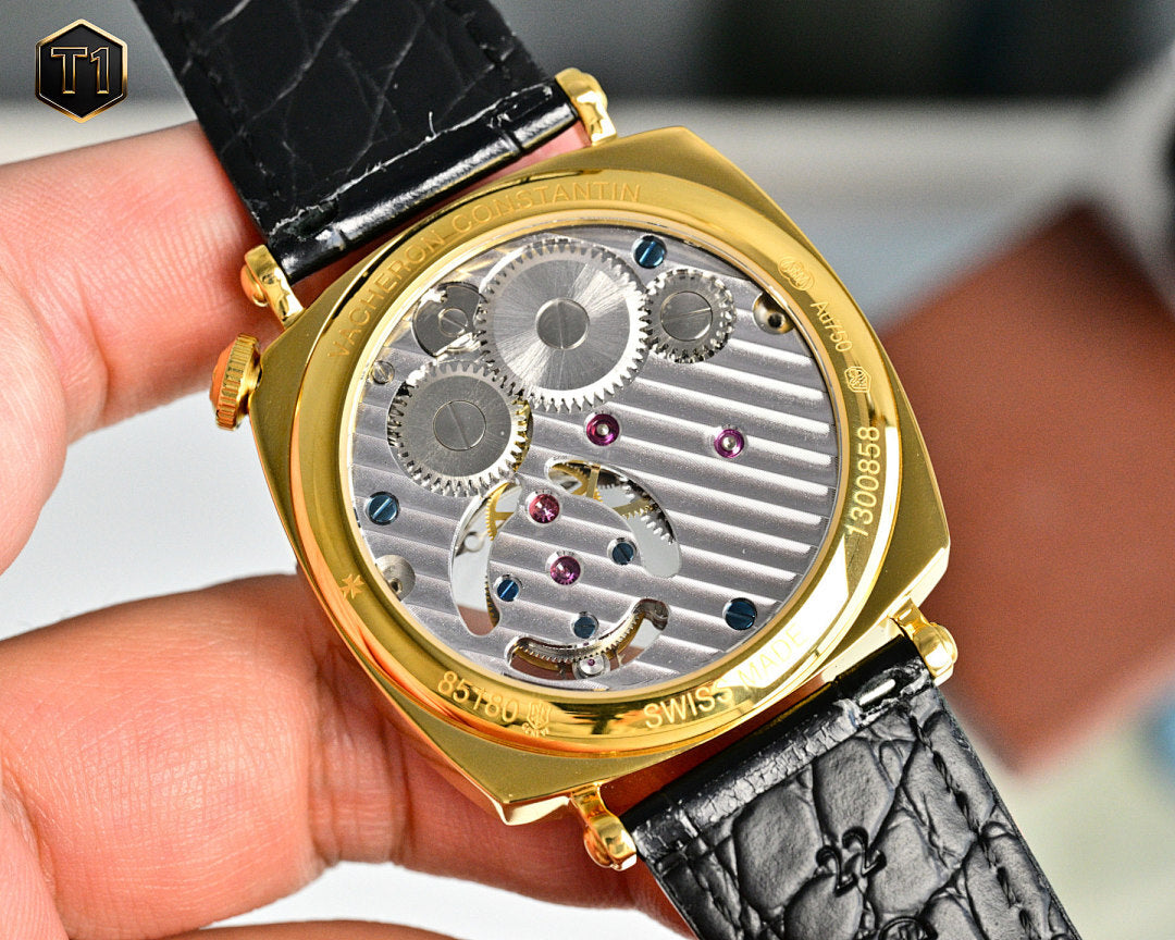 Vacheron Constantin watch with gold case and exposed mechanical movement, black leather strap