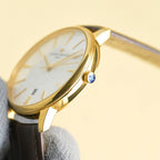 Vacheron Constantin watch side with gold crown featuring blue accent and brown leather strap