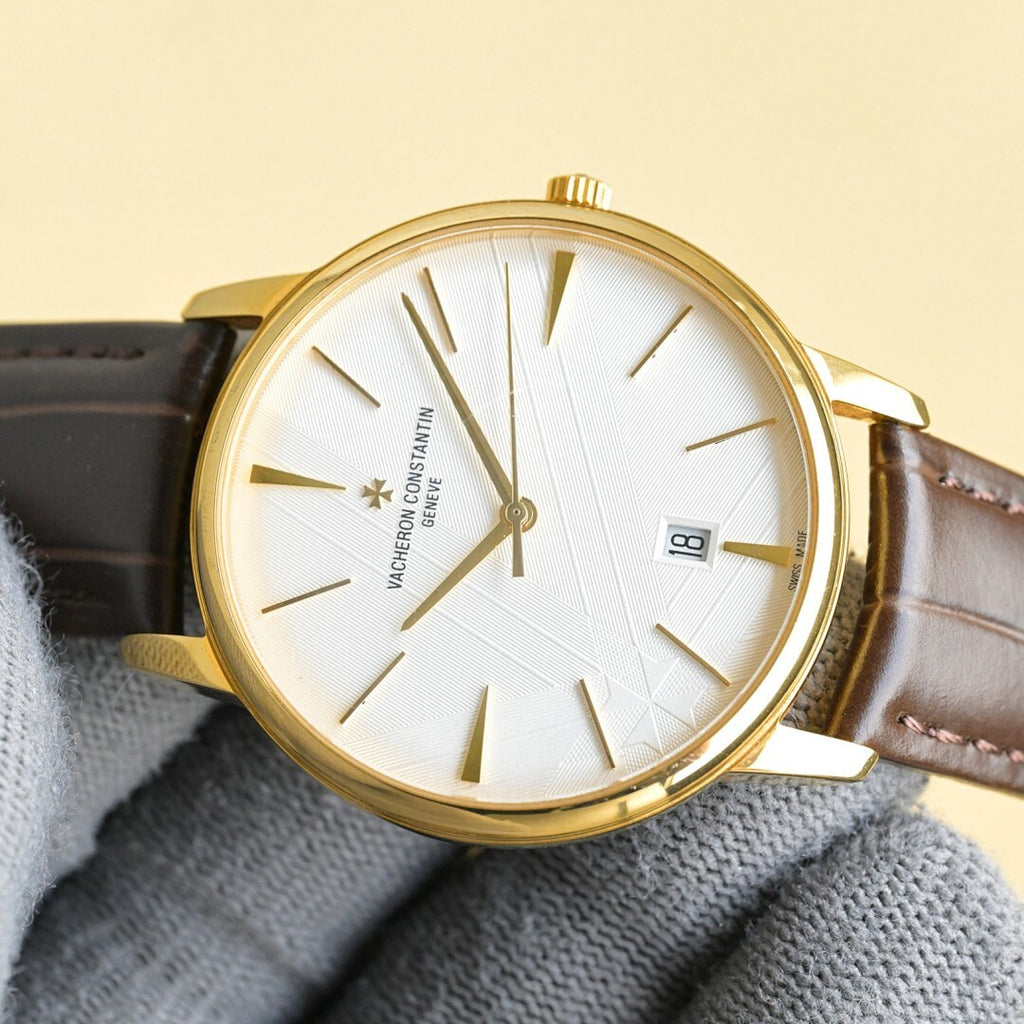 Vacheron Constantin watch face with white dial, gold bezel, brown leather strap