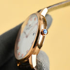 Gold Vacheron Constantin watch with crown detail and black strap, side profile