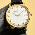 Gold Vacheron Constantin watch with white dial, diamond markers, black leather strap