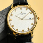 Gold Vacheron Constantin watch with white dial, diamond markers, black leather strap