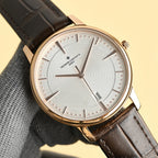 Vacheron Constantin watch with white dial, gold-tone bezel, and black leather strap