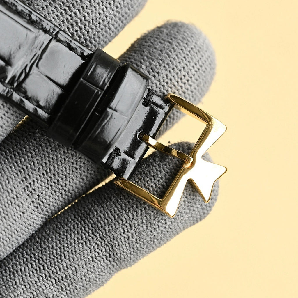 Luxury wristwatch black leather strap with gold buckle clasp and stitching detail