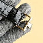 Luxury wristwatch black leather strap with gold buckle clasp and stitching detail