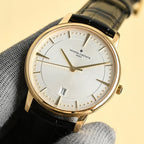 Luxury wristwatch with white dial, gold markers, black leather strap and analog hands