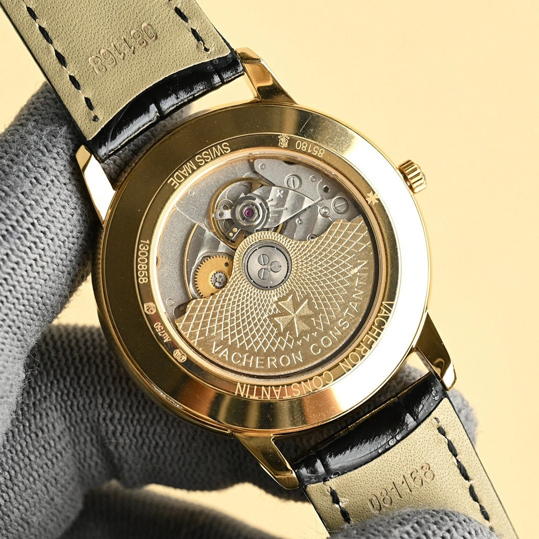 Luxury wristwatch back with gold case, black leather strap, engraved movement cover