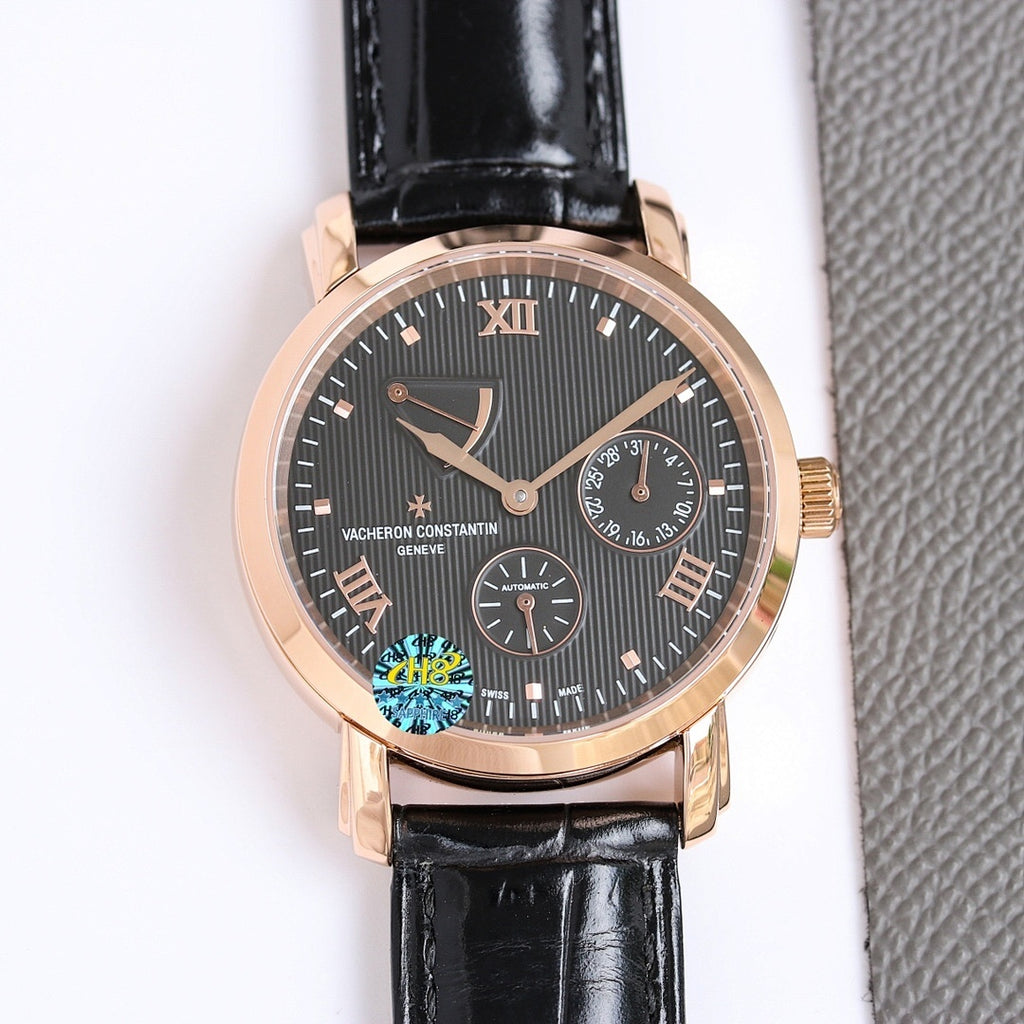 Gold-tone wristwatch with dark dial, Roman numerals, black leather strap, date window.