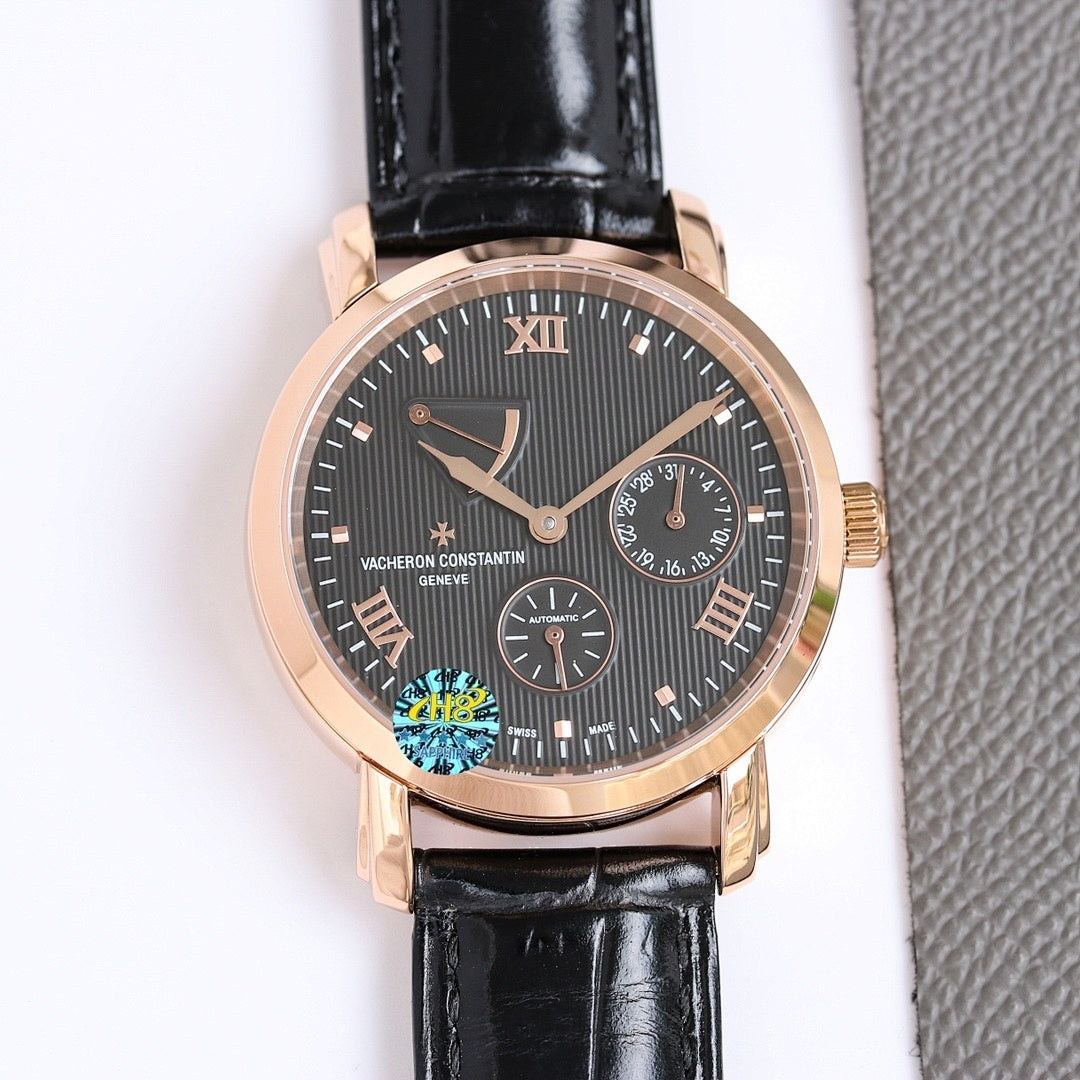 Gold-tone wristwatch with dark dial, Roman numerals, black leather strap, date window.