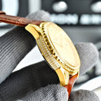 Gold-tone watch bezel with clear stones and brown leather strap