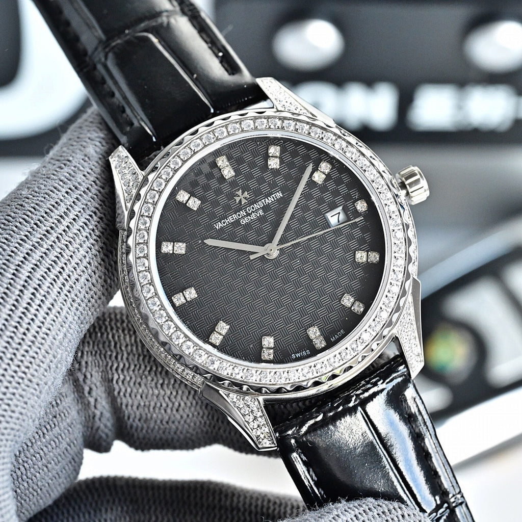 Silver-tone watch with dark textured dial, black leather strap, jeweled bezel, date window
