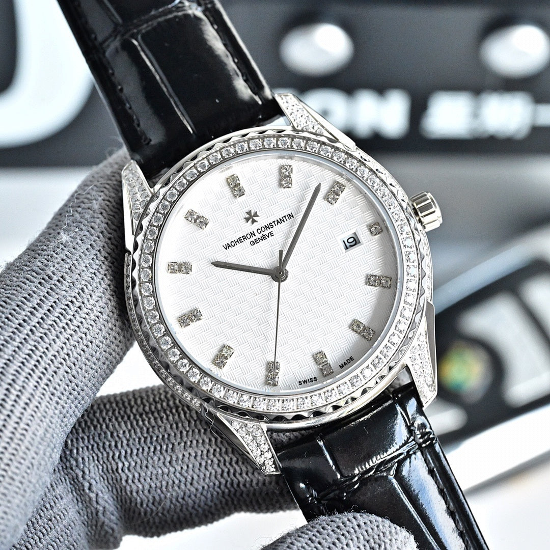 Silver-tone watch with white dial, black leather strap, jeweled bezel, date window at 6