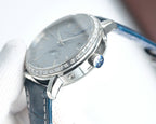 Luxury wristwatch side with silver crown, faceted bezel, and blue leather strap.