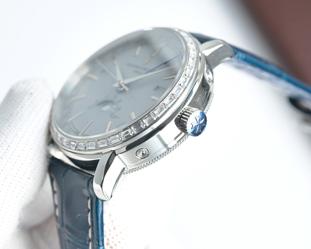 Luxury wristwatch side with silver crown, faceted bezel, and blue leather strap.