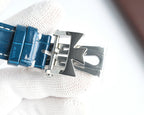 Blue leather watch strap with silver deployant buckle clasp and folded clasp hardware.