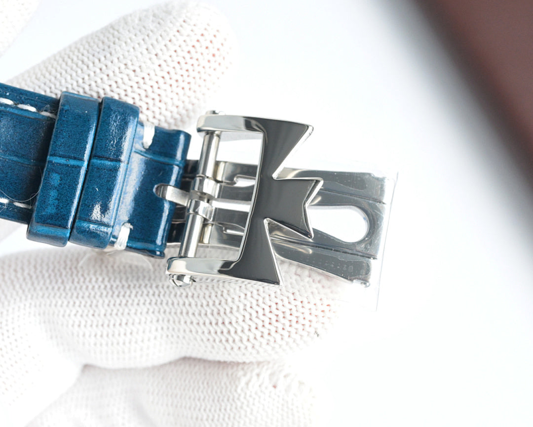 Blue leather watch strap with silver deployant buckle clasp and folded clasp hardware.