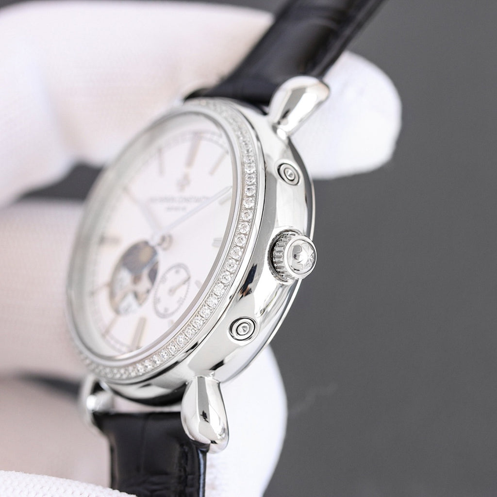 Silver watch side view with black leather strap and round crown detail