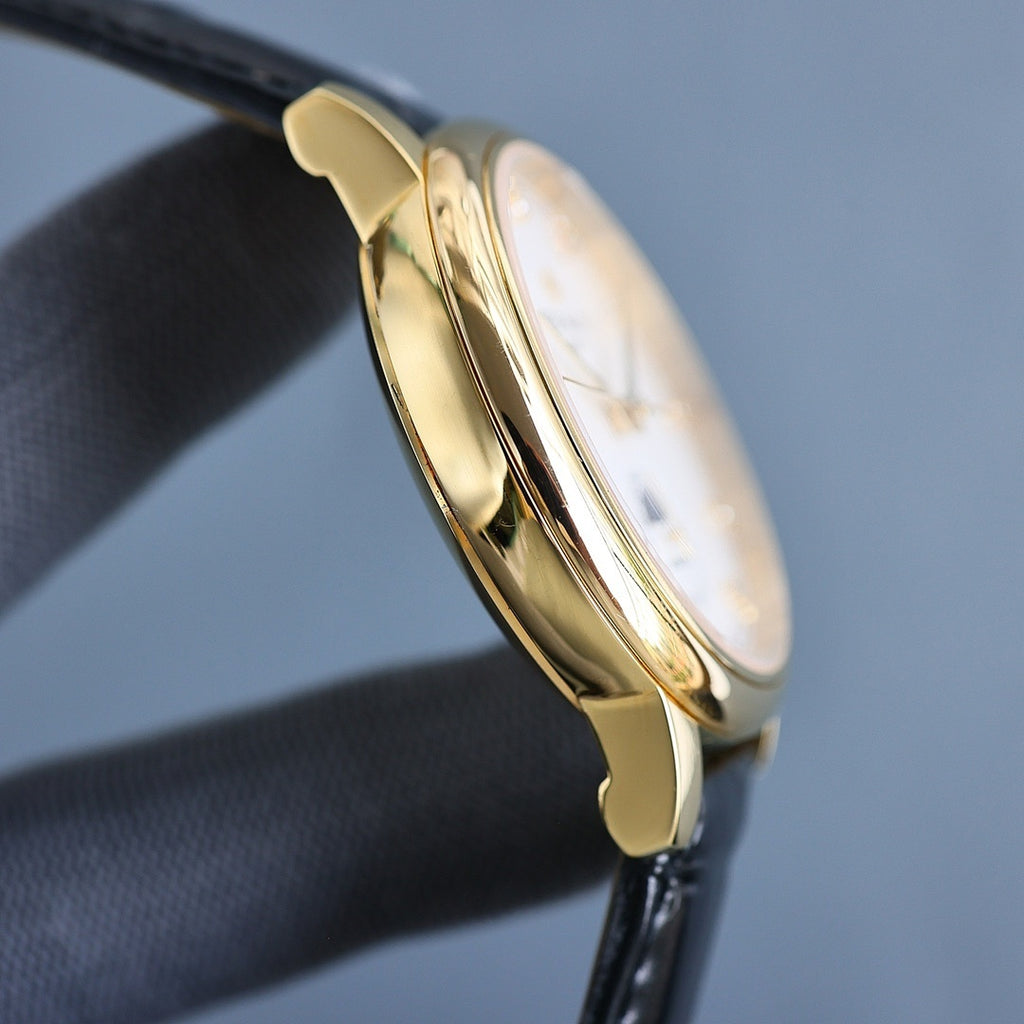 Gold wristwatch case side profile with black leather strap; polished finish.