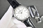 Vacheron Constantin watch with white dial, black leather strap, and silver case