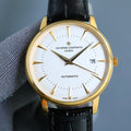 Gold-tone automatic wristwatch with white dial, black leather strap, gold hands and markers.