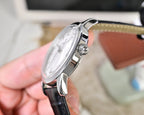 Wristwatch side profile with crown and silver case, black leather strap