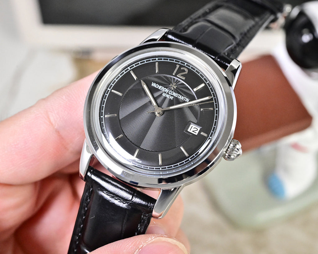 Wristwatch with black dial and silver bezel, black leather strap, three-quarter view