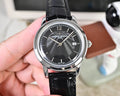Wristwatch with dark dial, silver case, and black leather strap