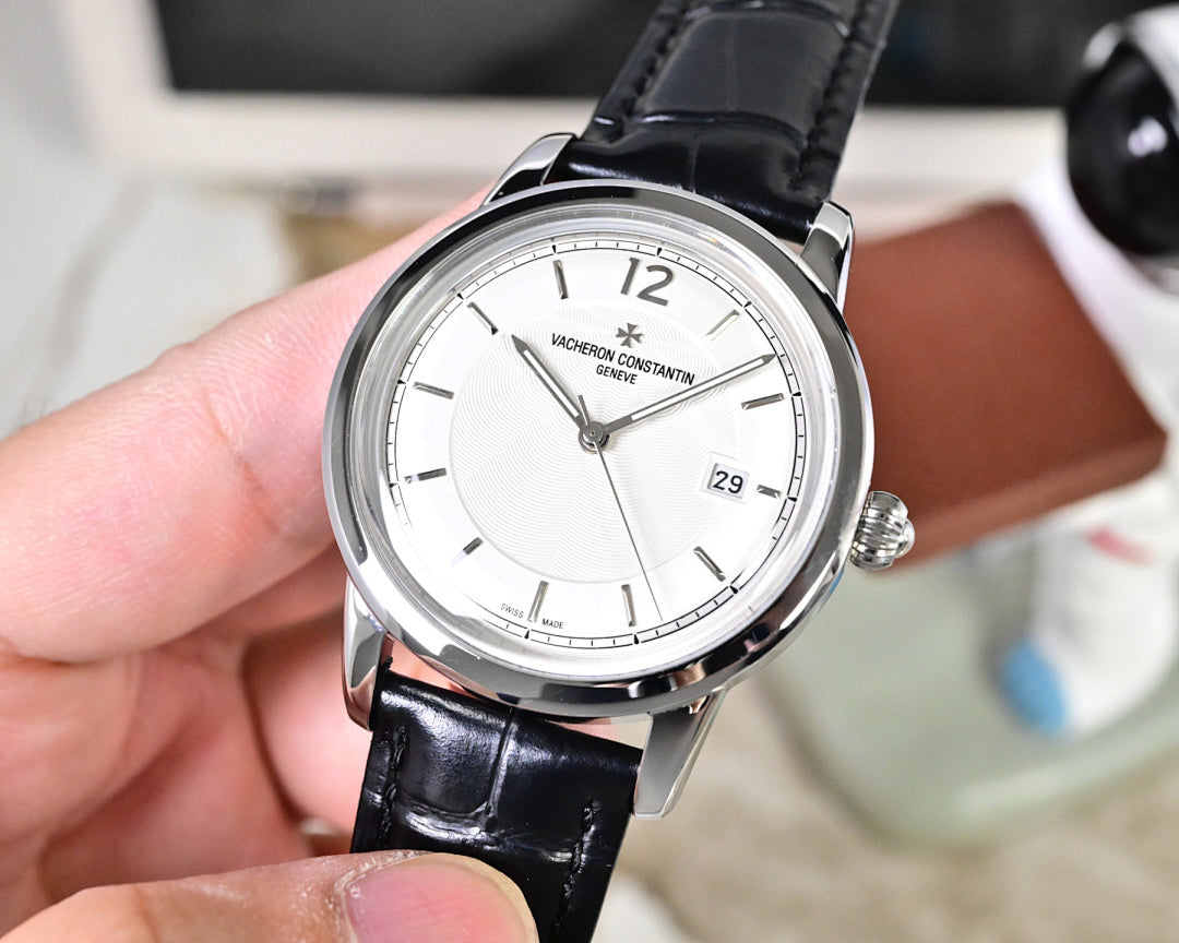 Wristwatch with white dial and silver bezel, black leather strap, three-quarter view