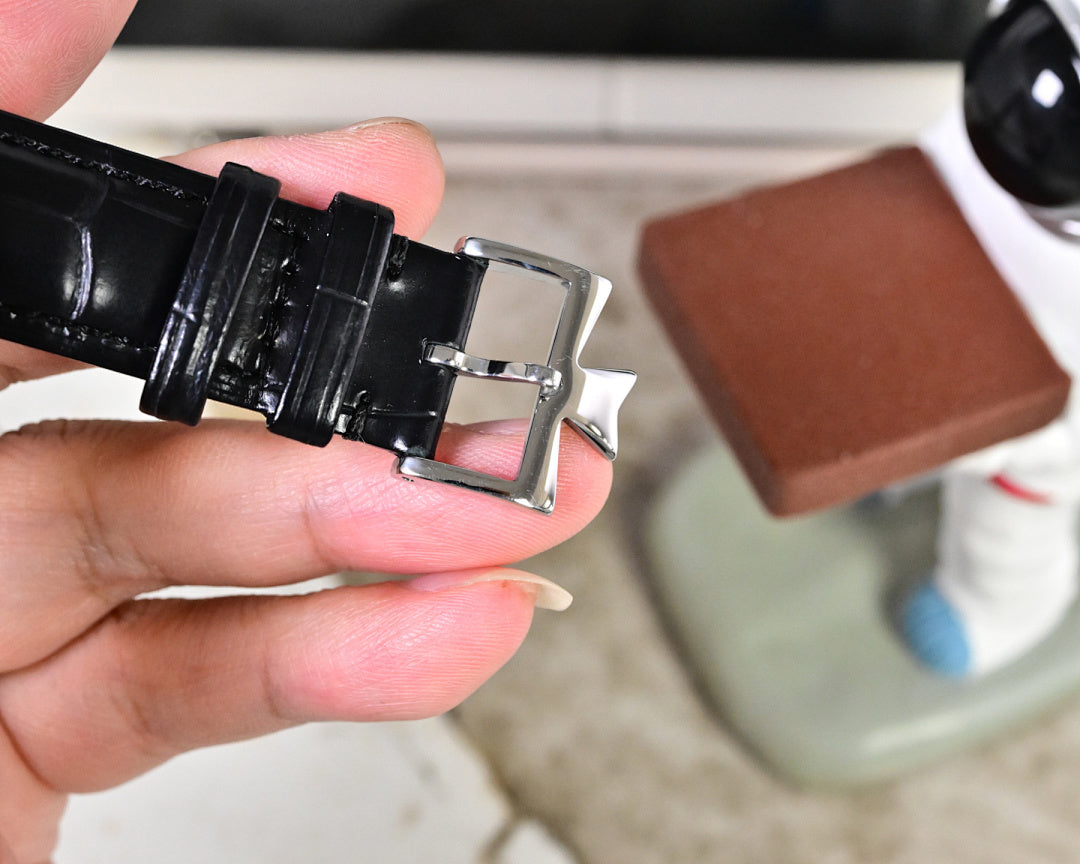 Wristwatch leather strap with silver buckle clasp, side view