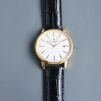 Vacheron Constantin wristwatch: white dial, black leather strap, gold case, date at 8.
