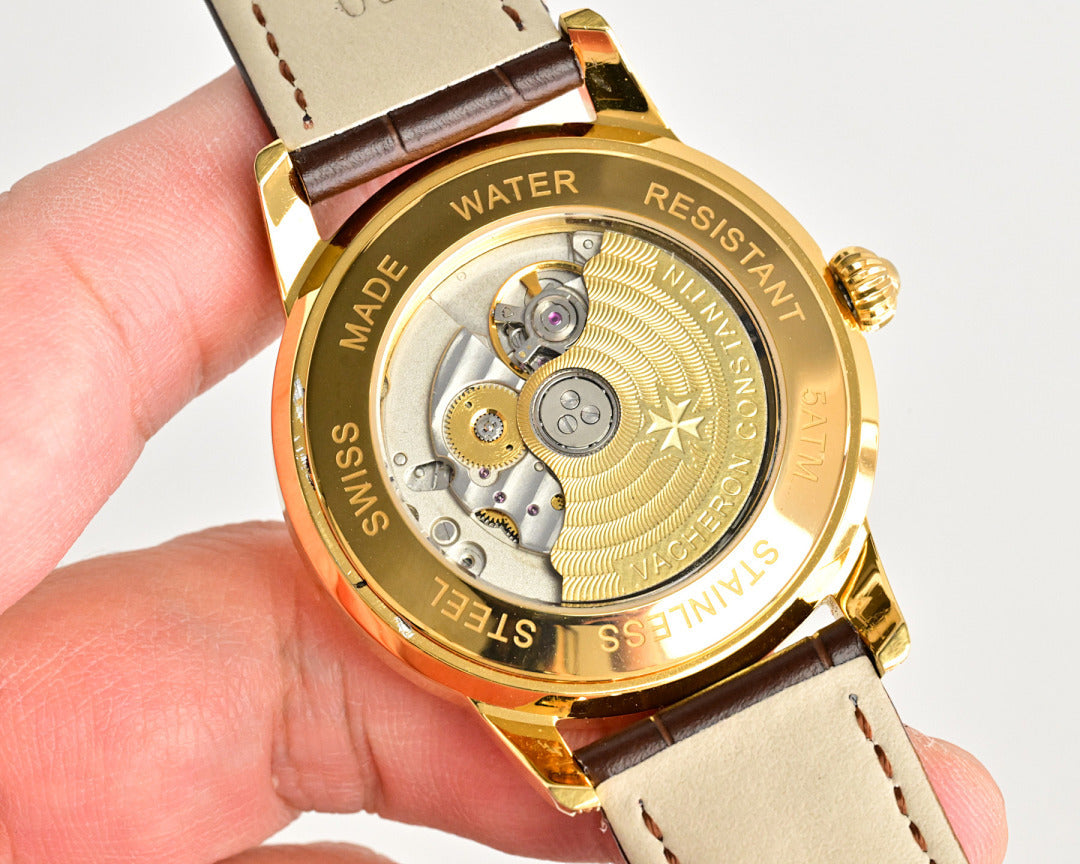 Gold watch caseback with visible movement and WATER RESISTANT text