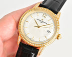 Gold-tone wristwatch with diamond bezel, black leather strap, white dial