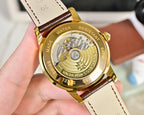 Gold-tone watch caseback with brown leather strap and stamped markings