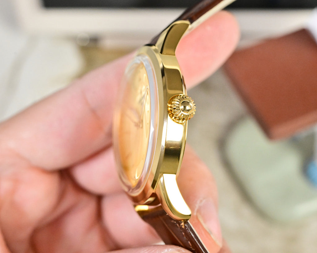 Gold-tone wristwatch side profile with brown leather strap