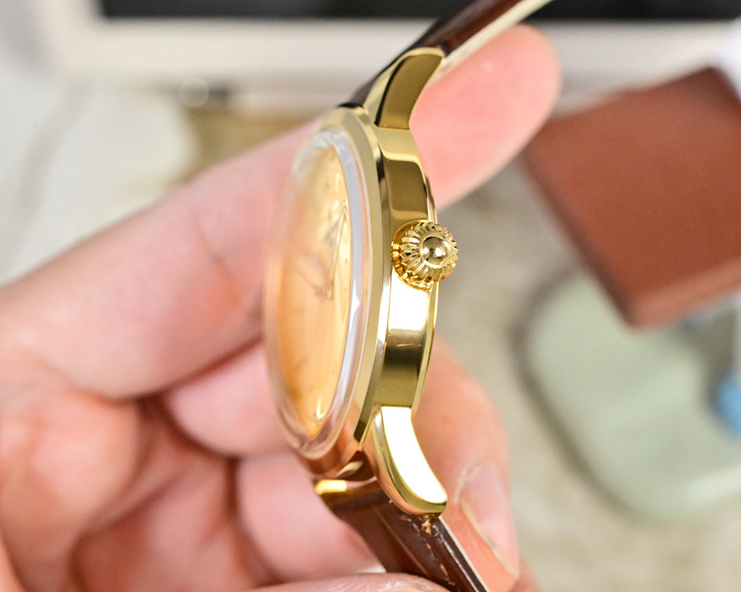 Gold-tone wristwatch side profile with brown leather strap