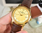 Gold-tone wristwatch with yellow dial and brown leather strap, front view