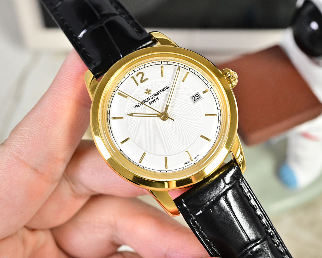 Gold-tone wristwatch with white dial and black leather strap, angled view