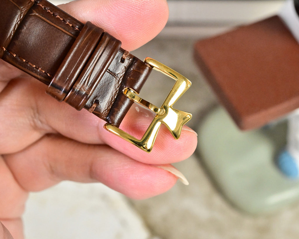 Brown leather watch strap with gold-tone buckle detail