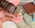 Brown leather watch strap with gold-tone buckle detail