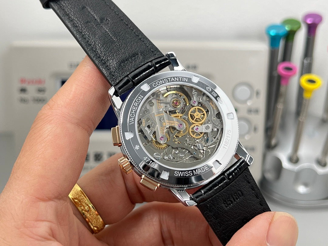 Mechanical watch caseback with visible movement, black leather strap and steel bezel.