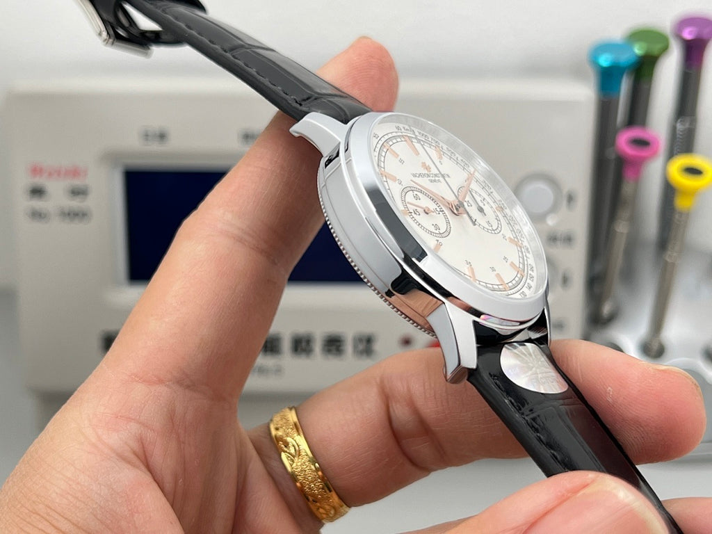 Round watch case with white dial and black leather strap, side profile with crown.