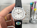 Chronograph wristwatch with white dial, black leather strap, rose-gold accents.