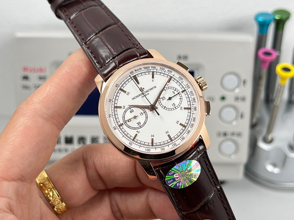 Rose gold tone chronograph watch with white dial and brown leather strap, angled view