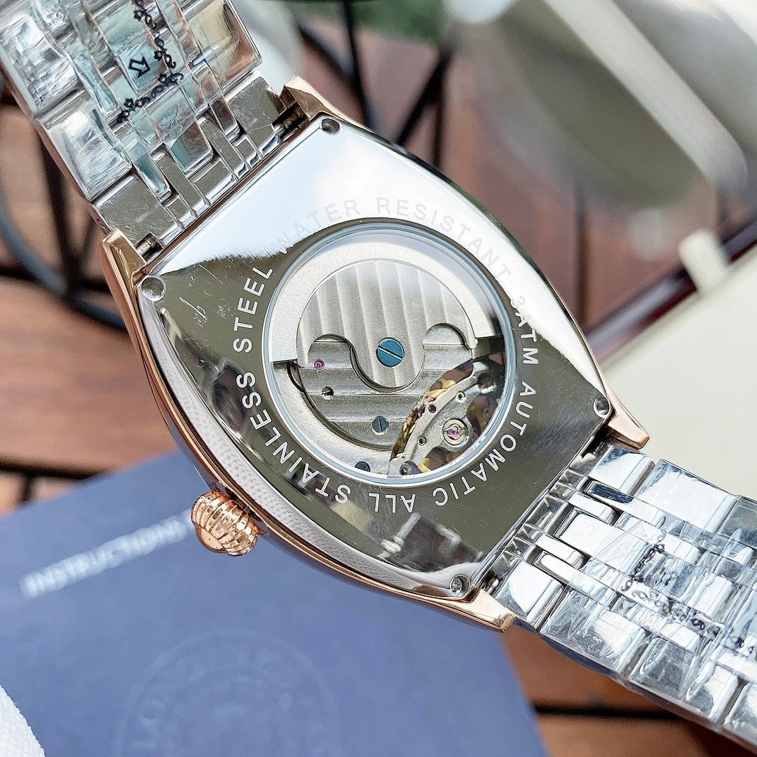 Gold-and-silver watch case with engraved text and visible mechanical movement